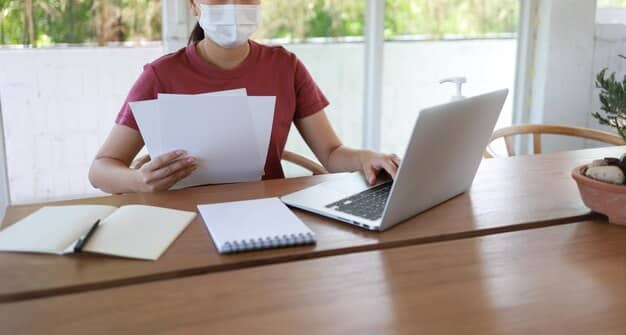 A person reviewing medical bills and HSA statements on their desk, with a laptop displaying an IRS webpage about HSA contribution limits in the background.