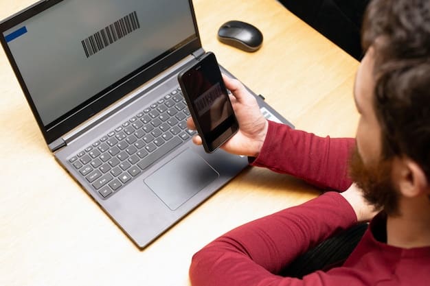 A smartphone displaying a two-factor authentication code being received via text message, with a blurred background showing account security settings on a laptop.