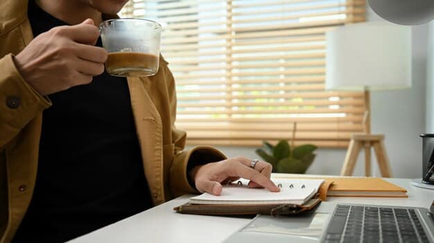 A person sitting at a desk with a laptop, reviewing documents related to student loans, with a calculator and coffee cup nearby, illustrating the process of managing and comparing loan options.