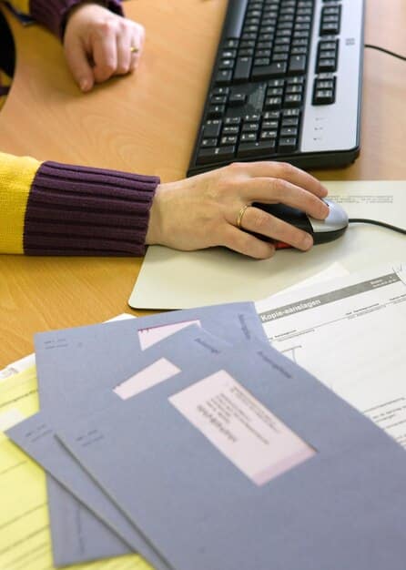 A close-up view of a FAFSA form being filled out on a desk with a laptop and calculator beside it, emphasizing the importance of completing the form to access work-study opportunities.