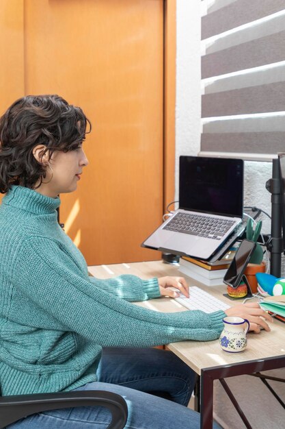 A student with a visual impairment using assistive technology to complete the FAFSA form on a laptop in a quiet study room. The scene emphasizes accessibility and determination.