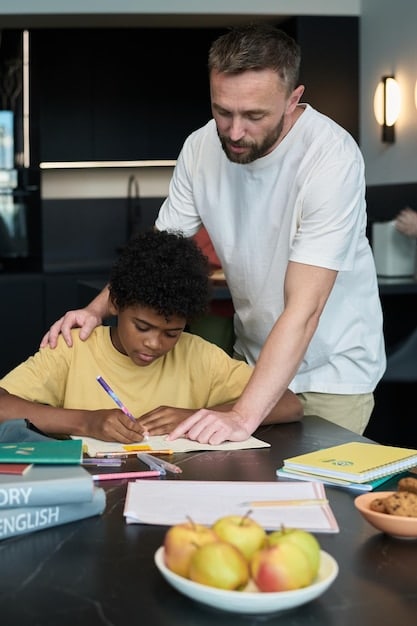 A parent is helping their child with homework at a kitchen table, using colorful teaching materials.