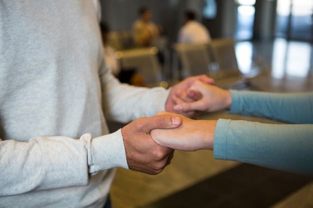 A close-up shot of two hands clasped together during a mentoring session, symbolizing trust and support. The background is blurred, focusing on the connection between the mentor and mentee.