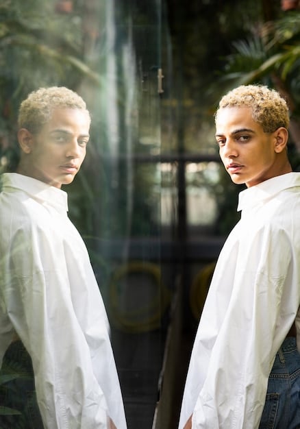 A person looking in a mirror, with their reflection showing both their current self and an idealized version, symbolizing self-reflection and striving for improvement.