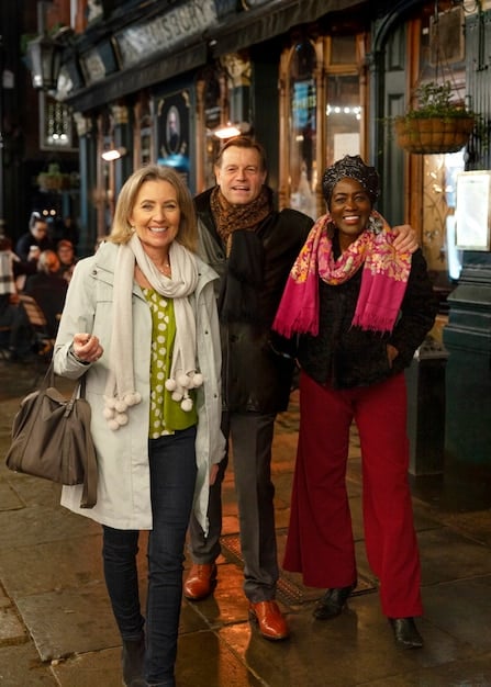 A vibrant street scene showing people of diverse ages and backgrounds wearing fashionable clothes, using smartphones, and interacting with street art, representing the fusion of technology, fashion, and urban culture.