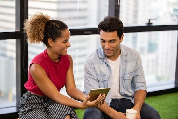 A digital nomad couple reviewing healthcare plan documents at a co-working space in Medellín, Colombia. They are using a laptop to compare different plan options on a spreadsheet and highlighting key information.