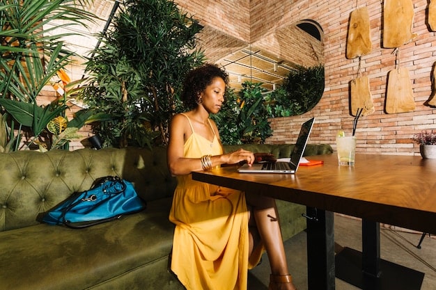 A digital nomad working on a laptop in a modern coworking space, surrounded by other professionals and a collaborative atmosphere. The scene should convey a sense of community, innovation, and productivity in a sleek and contemporary setting.